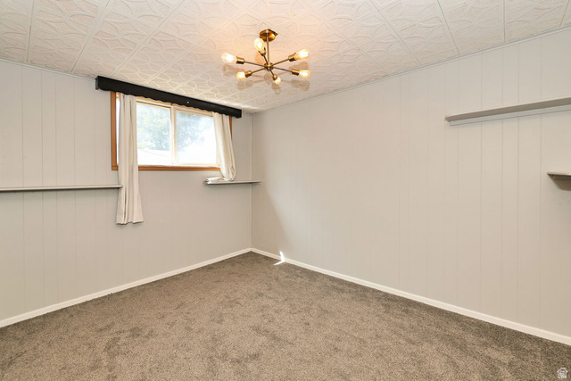 669 Colonial Avenue Layton, UT 84041 - Photo 26 of 51 Carpeted flooring, paneled walls, window with wooden trim, built-in shelving, and a decorative ceiling light fixture