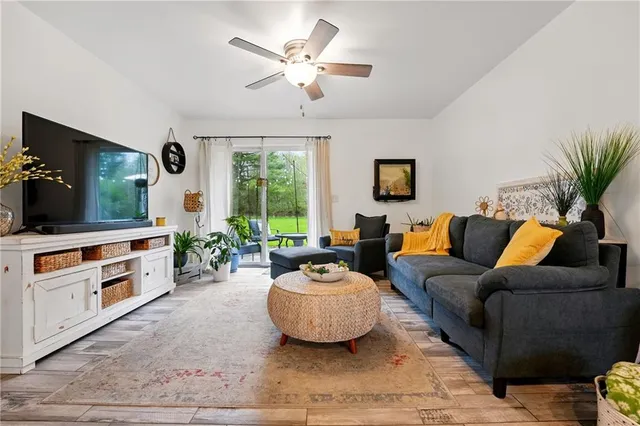 a living room with furniture a flat screen tv and a window