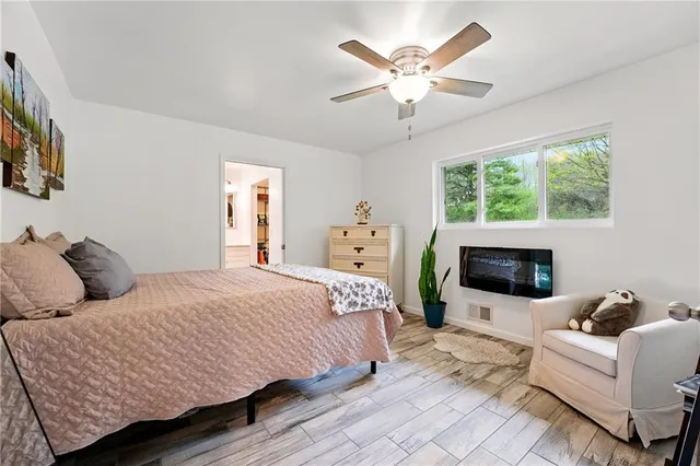 a bedroom with a large bed mirror and a fireplace