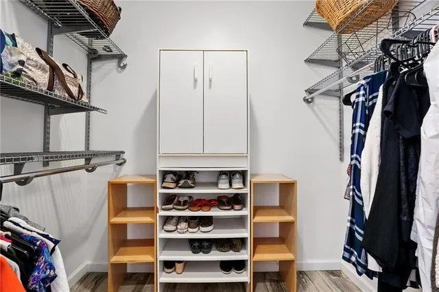 a view of walk in closet with clothes and shoes