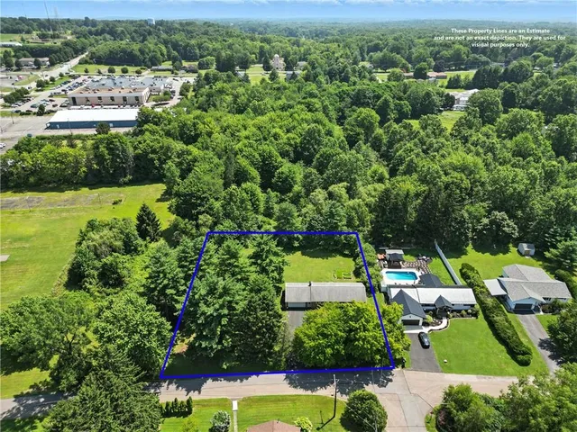 an aerial view of residential houses with outdoor space and trees