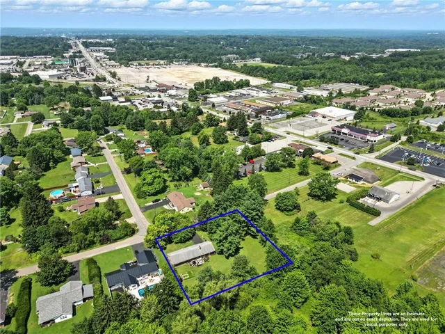 an aerial view of residential houses with outdoor space and trees