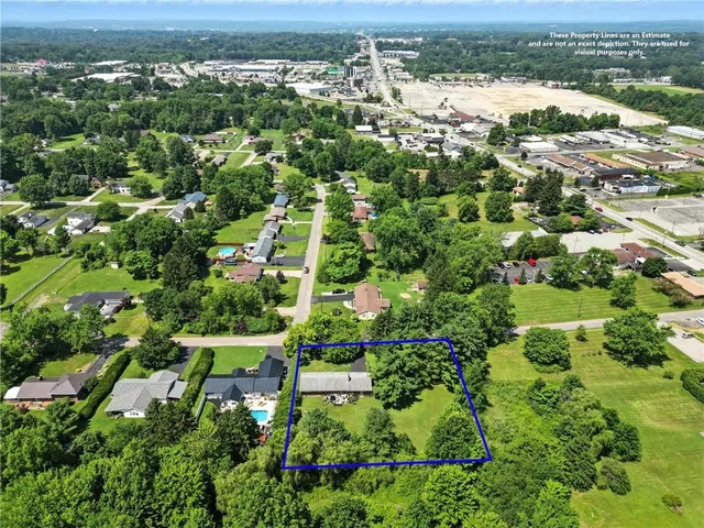 an aerial view of residential houses with outdoor space and trees
