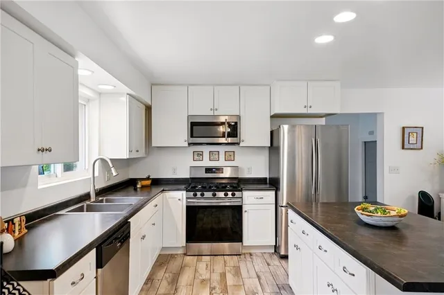 a kitchen with granite countertop a sink stove and refrigerator