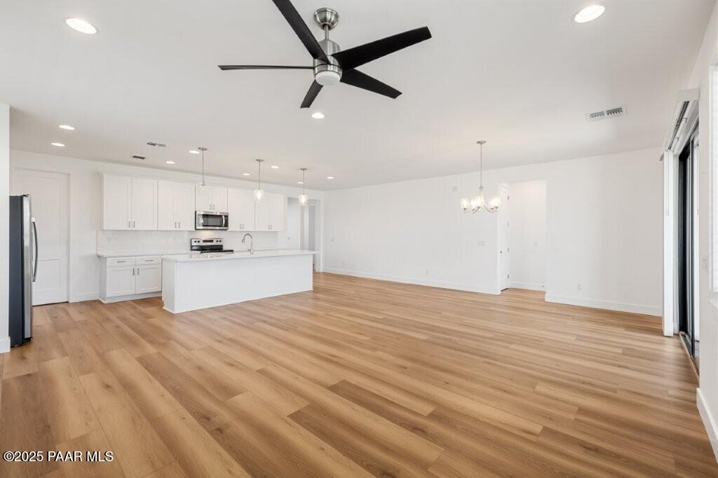 5008 Atwood Court Prescott Valley, AZ 86314 - Photo 11 of 34 a view of kitchen and empty room with wooden floor