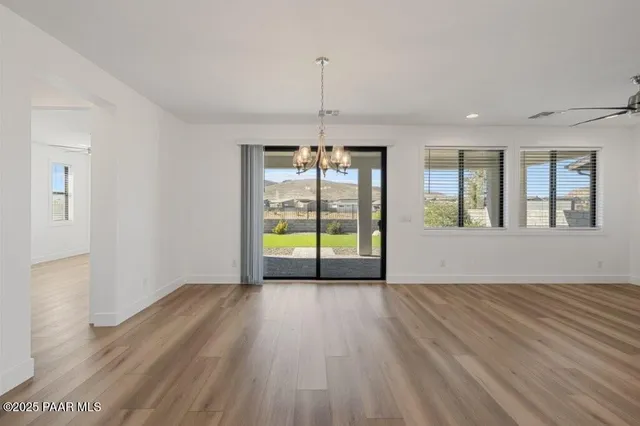 a view of an empty room with glass door and wooden floor