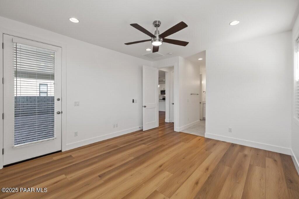 5008 Atwood Court Prescott Valley, AZ 86314 - Photo 16 of 34 a view of a big room with wooden floor a ceiling fan and windows