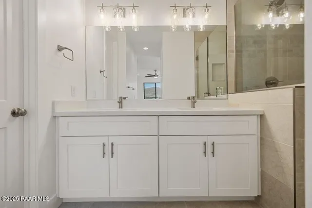 a bathroom with a sink vanity granite tub shower and a mirror