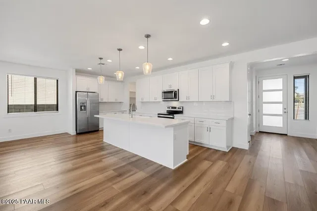 a view of a kitchen with wooden floor and electronic appliances