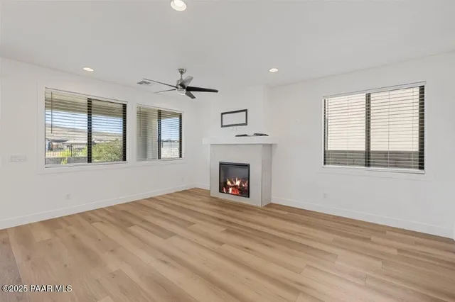 a view of an empty room with a window and fireplace