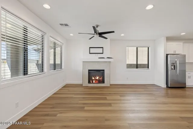 a view of an empty room with a fireplace and a window
