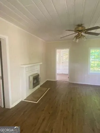 an empty room with windows and fireplace