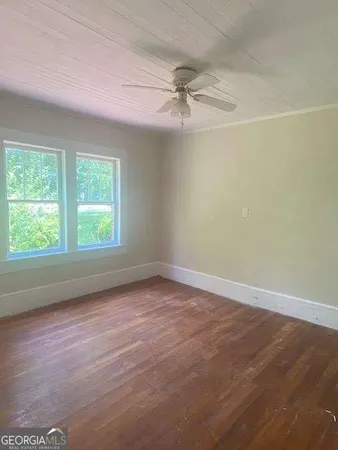 an empty room with a window and a fan