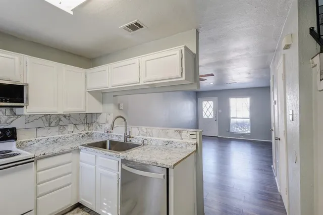 a kitchen with stainless steel appliances granite countertop a sink and cabinets