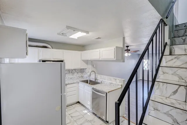 a kitchen with sink cabinets and refrigerator