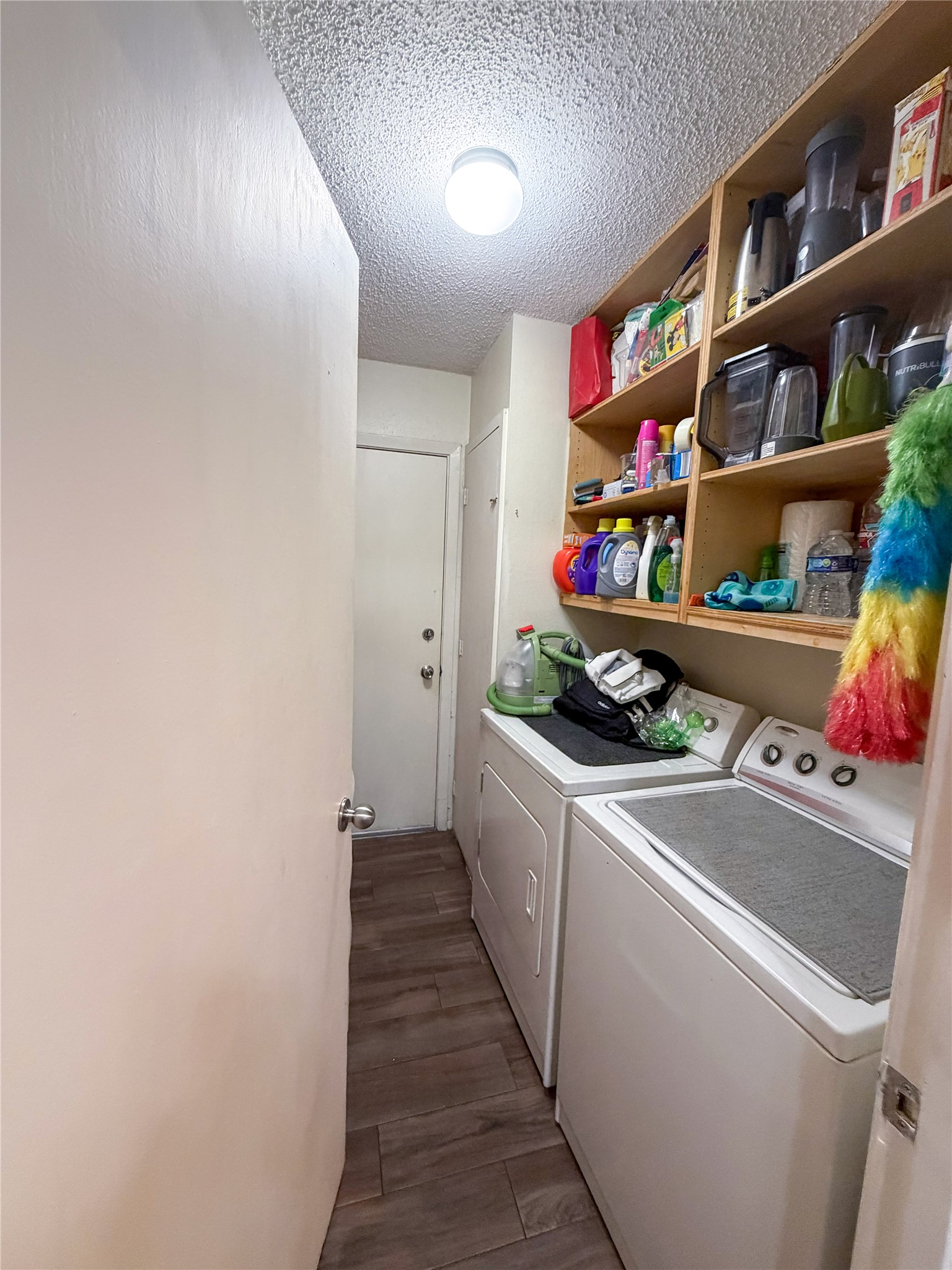 911 Kirschner Place, Unit A Austin, TX 78758 - Photo 12 of 12 Functional laundry area featuring convenient shelving and wood-look flooring. Washer and dryer included with lease.