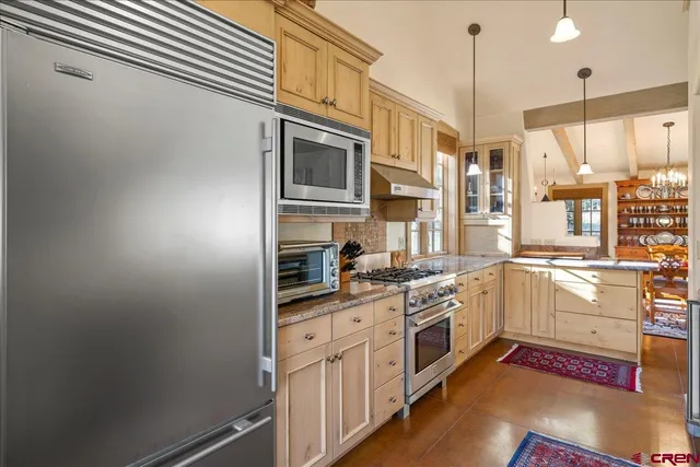 a kitchen with stainless steel appliances granite countertop a stove a sink and a refrigerator