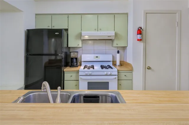 a kitchen with a refrigerator and a stove