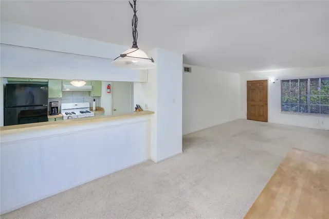 a view of a kitchen and a sink cabinet in an empty room