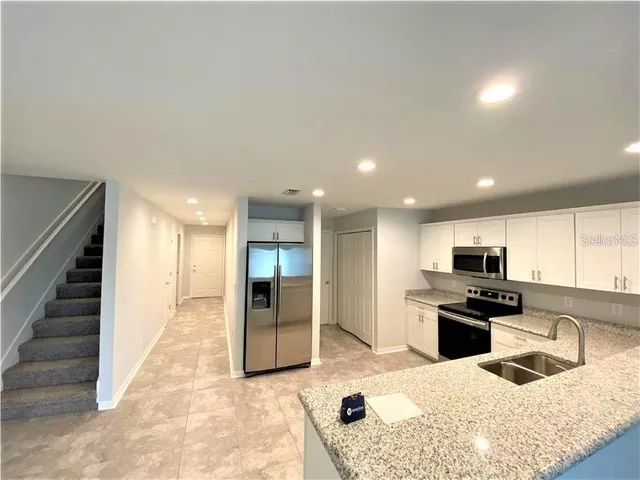 an empty room with windows and ceiling fan