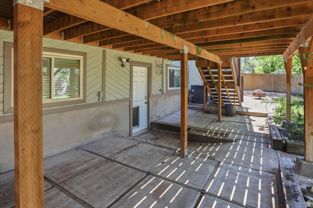 8938 Manchester Lane Sandy, UT 84093 - Photo 37 of 50 Covered patio area featuring a concrete slab foundation and exposed wooden beam ceiling