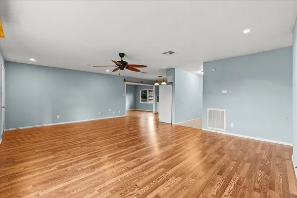 an empty room with a ceiling fan and a window