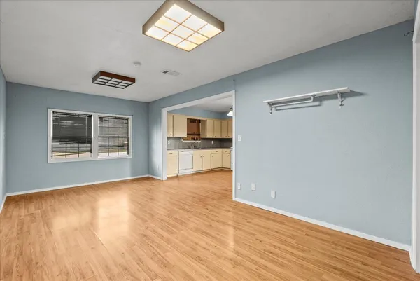 a view of a big room with wooden floor and a window