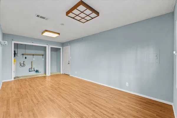 a white kitchen with granite countertop white cabinets stainless steel appliances a sink and wooden floor