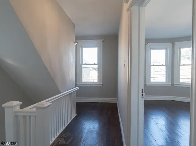 a view of a hallway with wooden floor and stairs