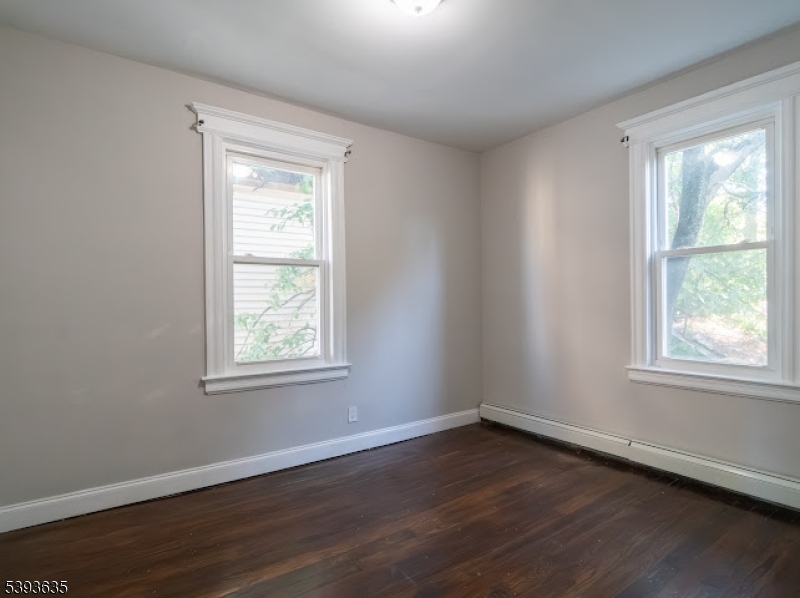 134 Maple Avenue Irvington, NJ 07111 - Photo 16 of 29 an empty room with wooden floor and windows