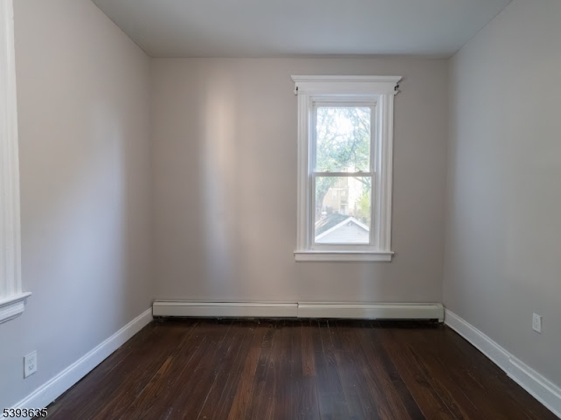 134 Maple Avenue Irvington, NJ 07111 - Photo 17 of 29 a view of an empty room with wooden floor and a window