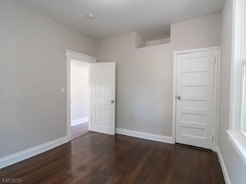 134 Maple Avenue Irvington, NJ 07111 - Photo 23 of 29 an empty room with wooden floor & closet area