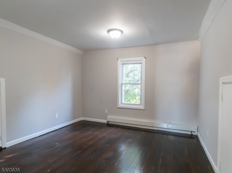 134 Maple Avenue Irvington, NJ 07111 - Photo 24 of 29 an empty room with wooden floor and windows