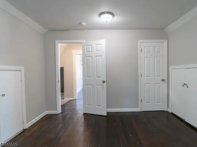an empty room with wooden floor & closet area