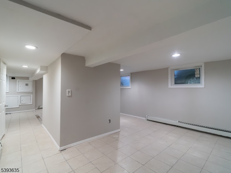134 Maple Avenue Irvington, NJ 07111 - Photo 27 of 29 an empty room with a empty space and windows