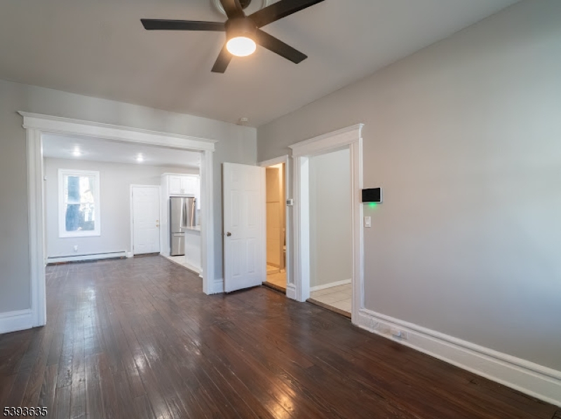 134 Maple Avenue Irvington, NJ 07111 - Photo 6 of 29 an empty room with wooden floor and windows