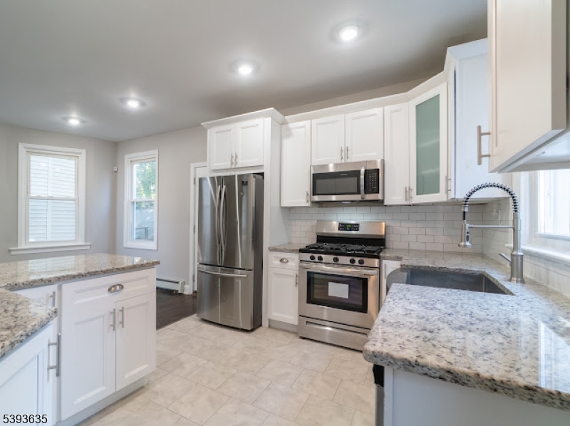 134 Maple Avenue Irvington, NJ 07111 - Photo 10 of 29 a kitchen with stainless steel appliances granite countertop a stove a sink and a refrigerator