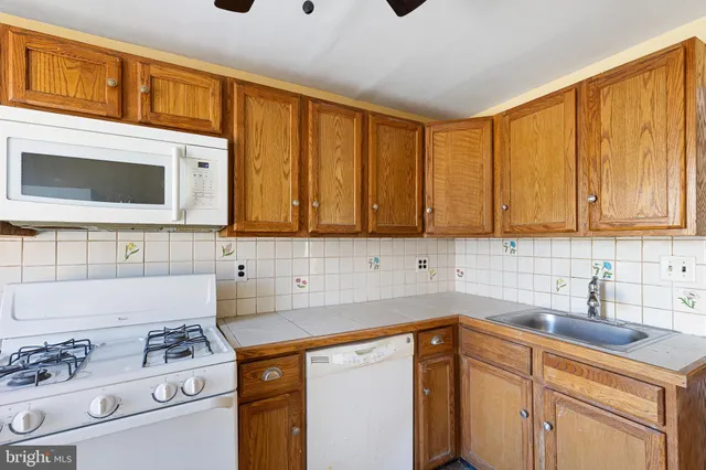 a kitchen with stainless steel appliances granite countertop a sink a stove and cabinets