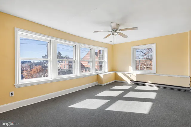 a living room with hard wood floors and a ceiling fan