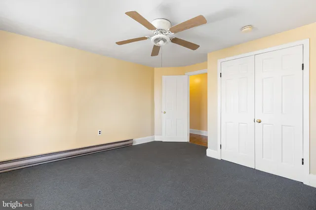 an empty room with closet and windows