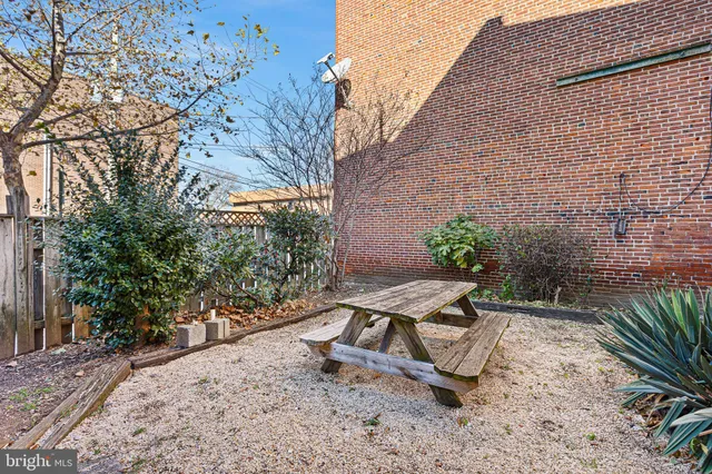 a wooden bench sitting in backside of a house