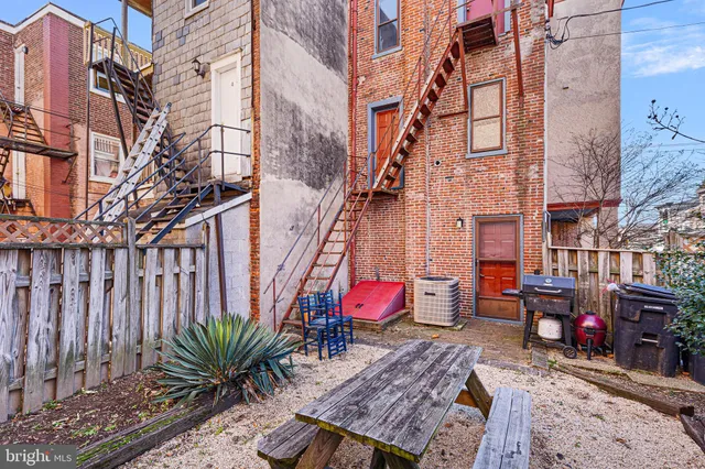 a view of a balcony with chairs potted plants and wooden fence