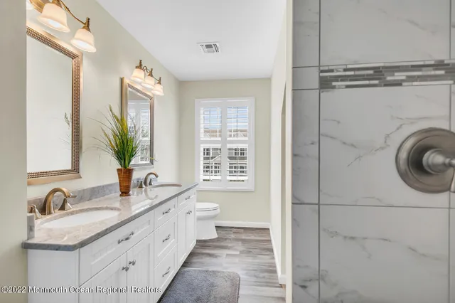 a bathroom with a granite countertop sink a mirror and a bathtub