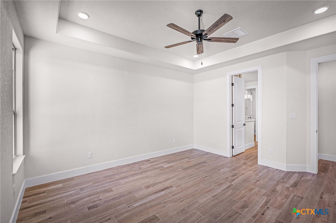 319 Serenity Pass Spring Branch, TX 78070 - Photo 14 of 26 an empty room with wooden floor and ceiling fan