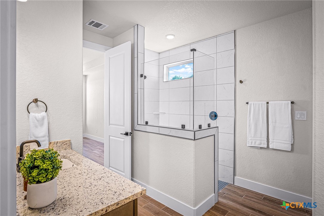 319 Serenity Pass Spring Branch, TX 78070 - Photo 15 of 26 a bathroom with a granite countertop sink a toilet and shower