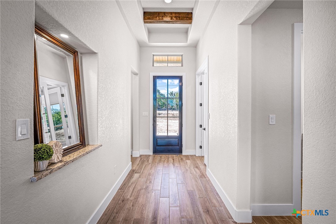 319 Serenity Pass Spring Branch, TX 78070 - Photo 5 of 26 a view of a hallway with wooden floor and a living room