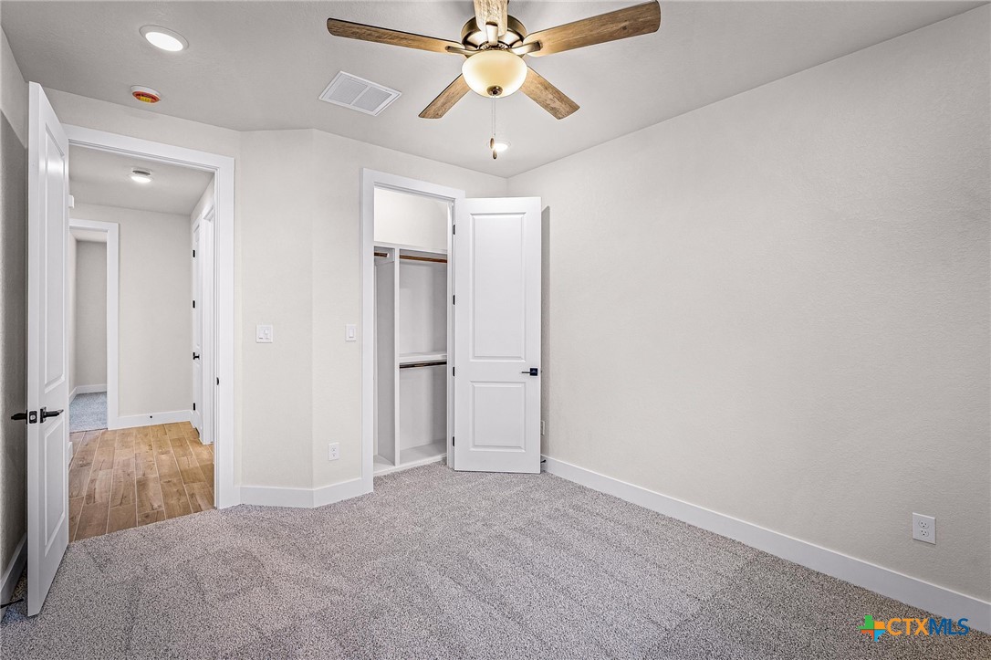 319 Serenity Pass Spring Branch, TX 78070 - Photo 9 of 26 wooden floor in an empty room with a chandelier fan