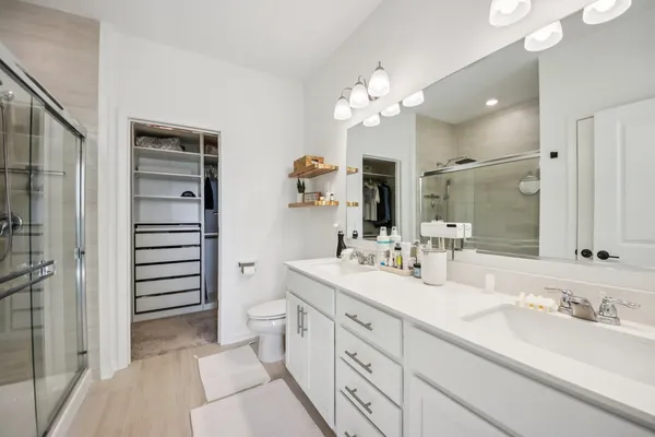 a bathroom with a double vanity sink mirror and toilet