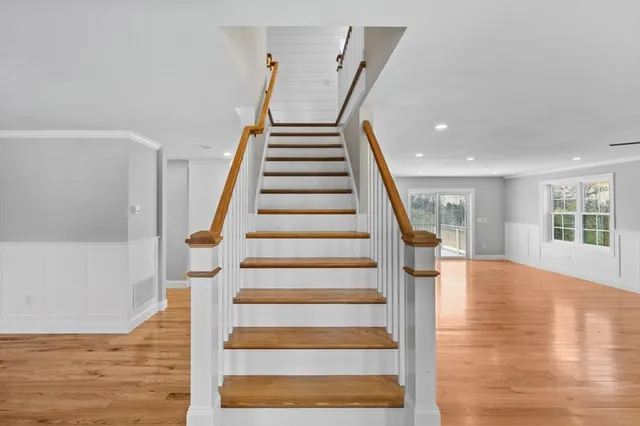 a view of a hallway with wooden floor and windows