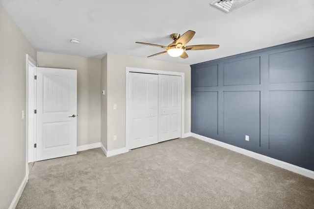 an empty room with closet and ceiling fan